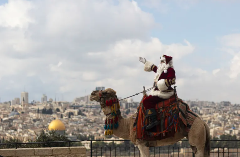 “بابا نويل” القدس يطوف شوارعها على ظهر جمل لنشر السعادة