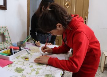طفلة ترسم طريق الأمل بالألوان في مركز الهلال الذهبي بالرقة