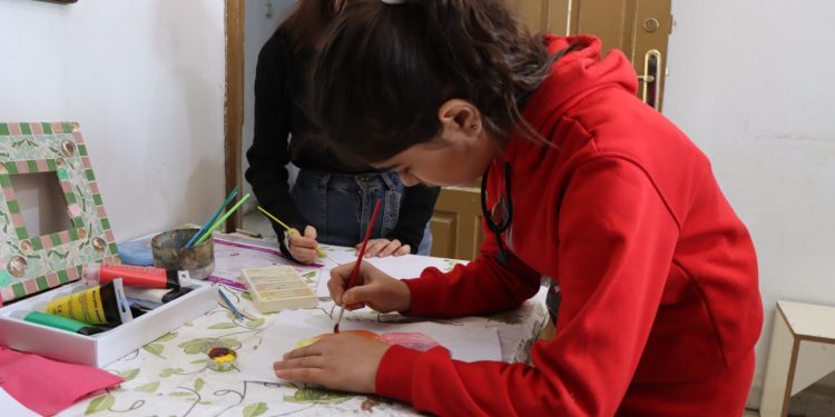 طفلة ترسم طريق الأمل بالألوان في مركز الهلال الذهبي بالرقة